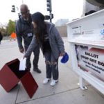 A young voter casts his ballot into the ballot box in downtown Denver November 8. (David Zalubowski/Associated Press)