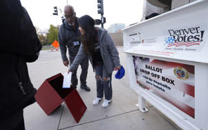 A young voter casts his ballot into the ballot box in downtown Denver November 8. (David Zalubowski/Associated Press)