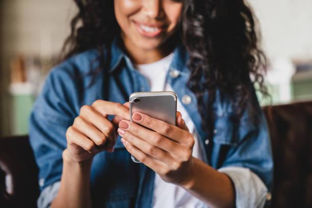 https://media.istockphoto.com/id/1313901506/photo/cropped-shot-of-an-african-american-young-woman-using-smart-phone-at-home-smiling-african.jpg?b=1&s=612x612&w=0&k=20&c=t0ZJ3i_AZr8RWYu2Q7yPhJC6q01owZTcR4_S-WH5564=