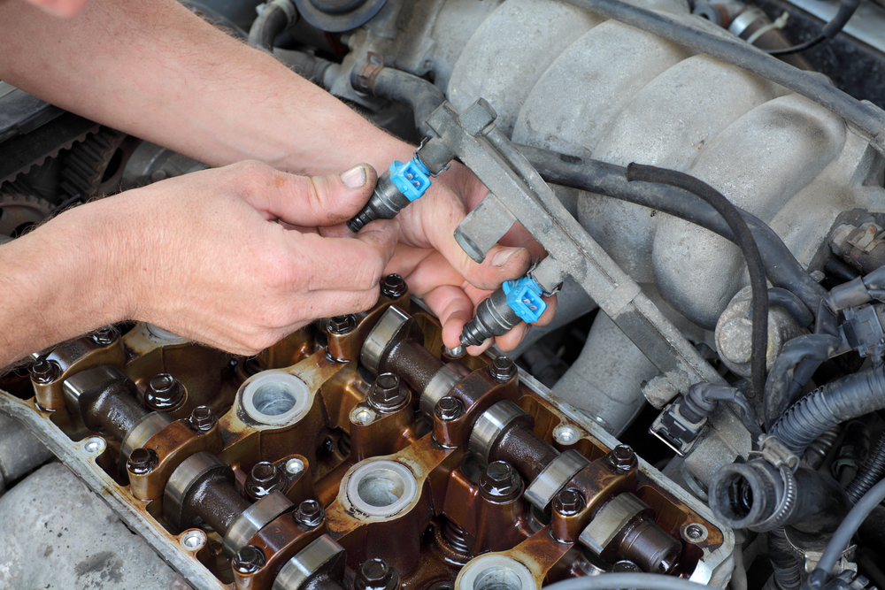 car mechanic cleaning car injectors