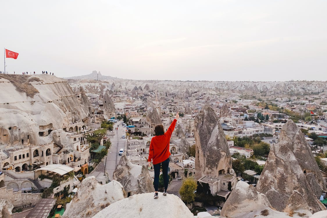 Traveler on a cliff overlooking an ancient city 