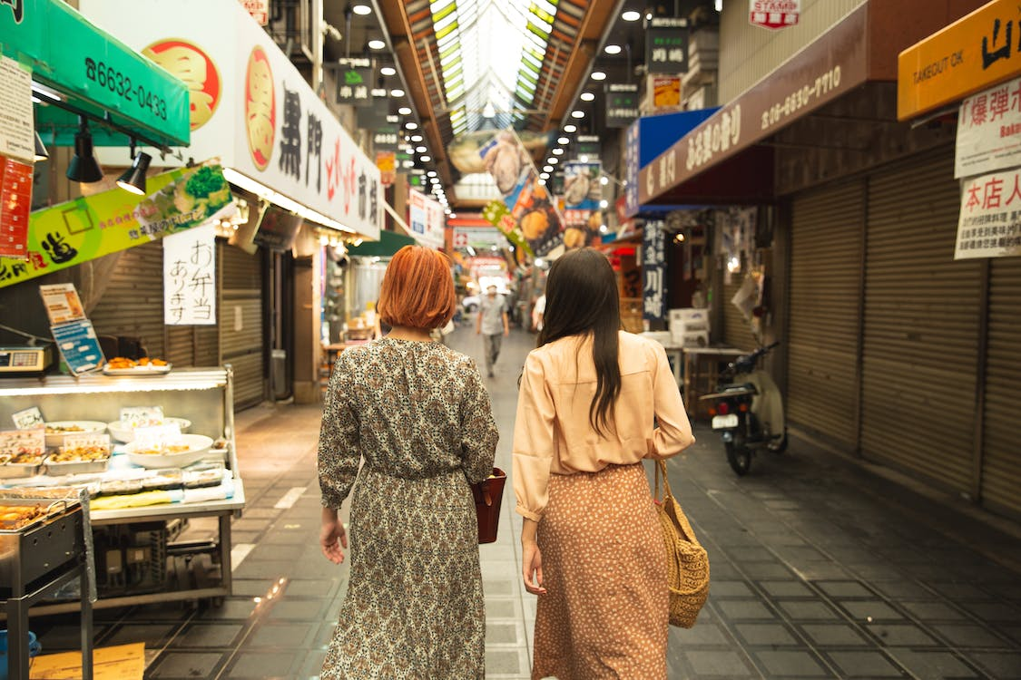 emale travelers walking through an Asian market